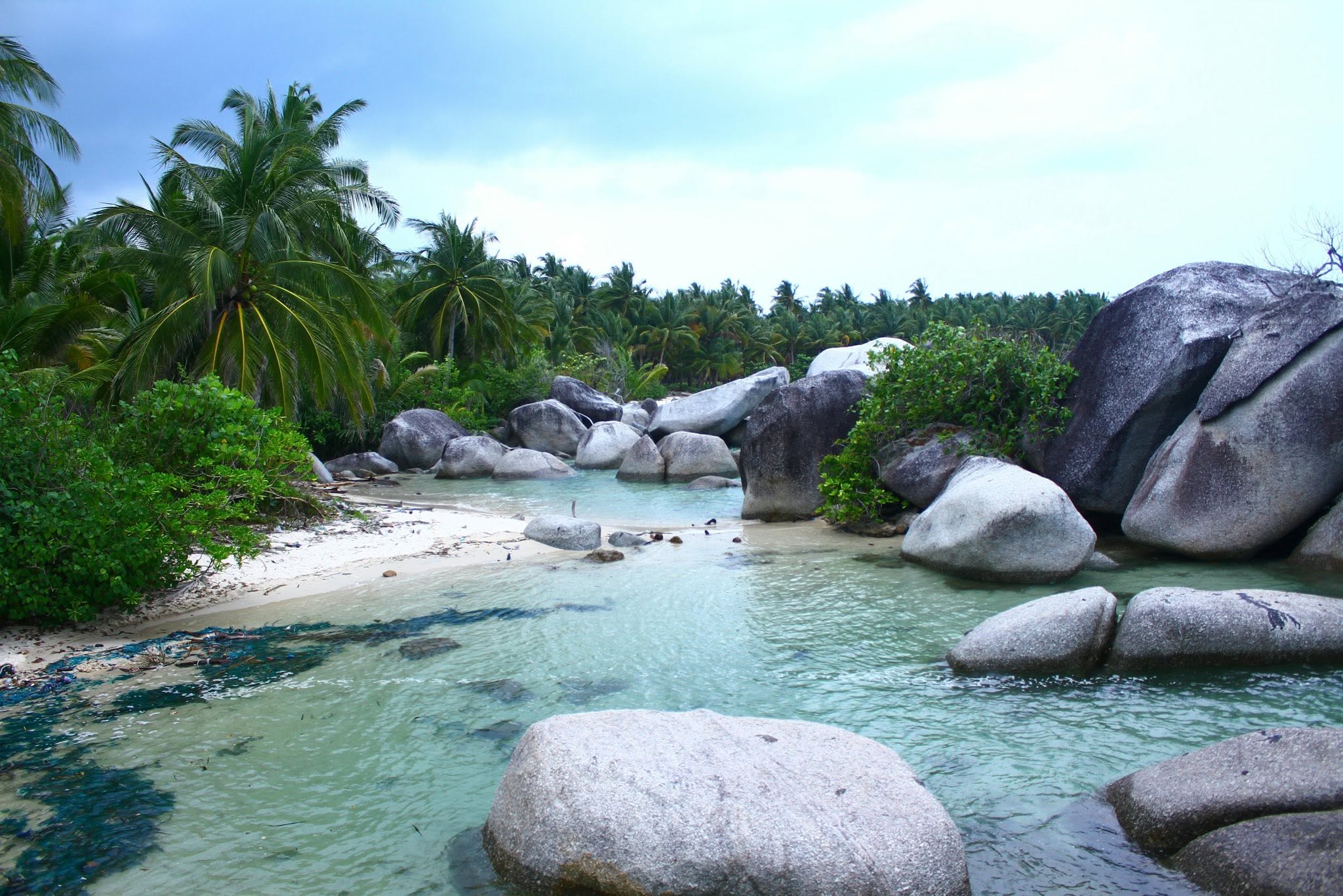 A beach with granite boulders and turquoise water