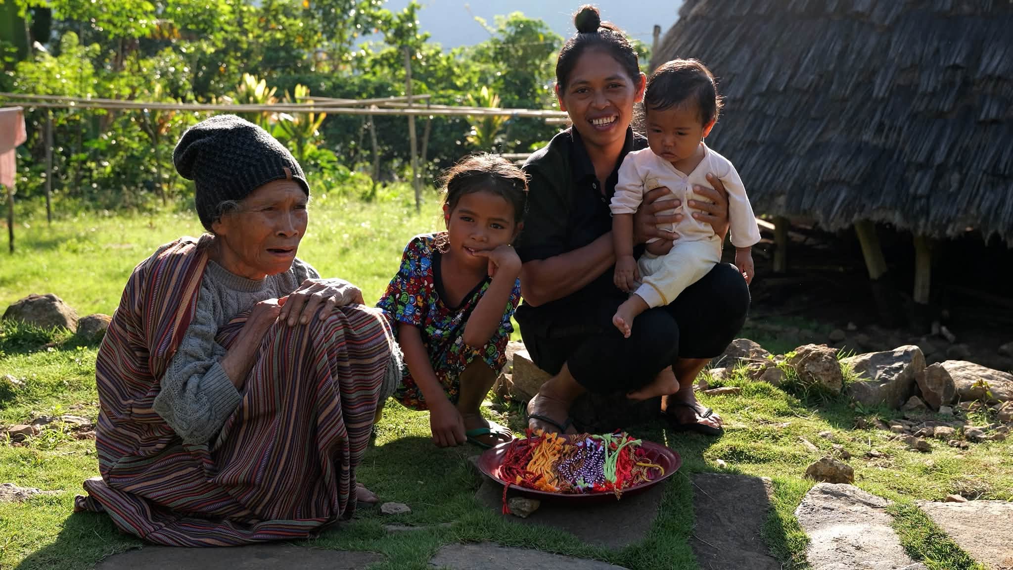 A smiling family in a village on Flores